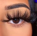 Close-up of a brown eye wearing long, wispy, voluminous Lash style classy false eyelashes.